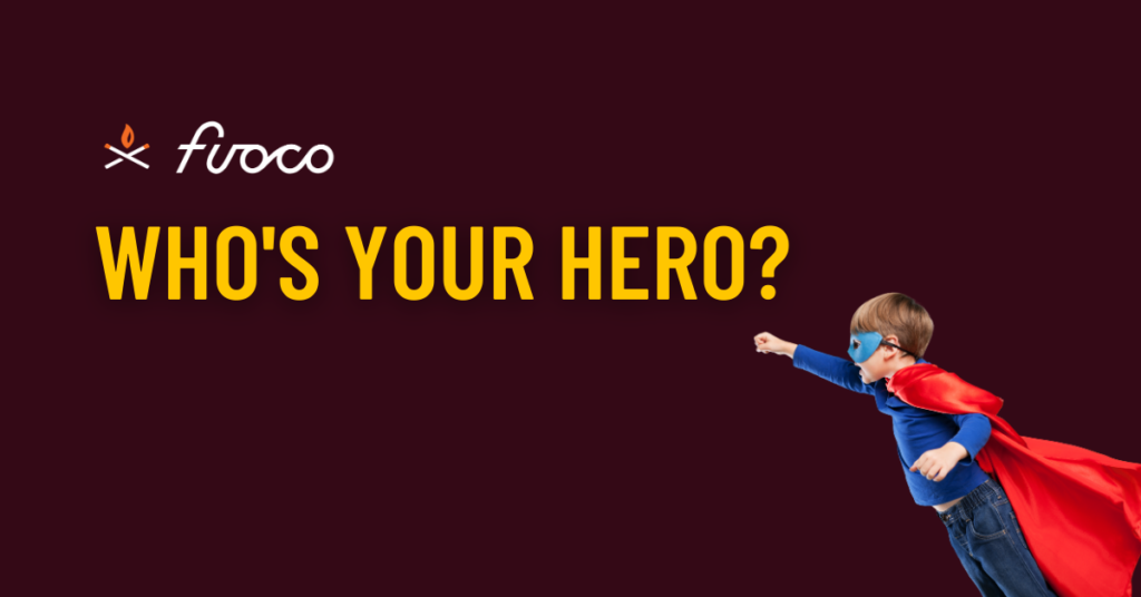 Image of young boy in blue suit and cape. Maroon background and text that reads "who's your hero?"