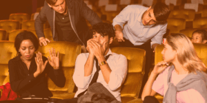 5 young adults sitting and standing around a couch